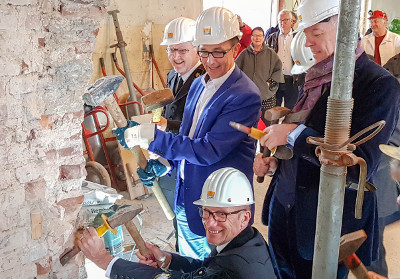 Akteure schlagen Putz von den Wänden