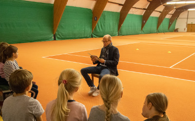 Müllmann liest auf dem Tennisplatz