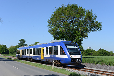 LINT 41 Triebfahrzeug der NordWestBahn auf der Gleistrasse neben der Haarbeckstraße. Im Hintergrund sieht man den Förderturm von Schacht 1.