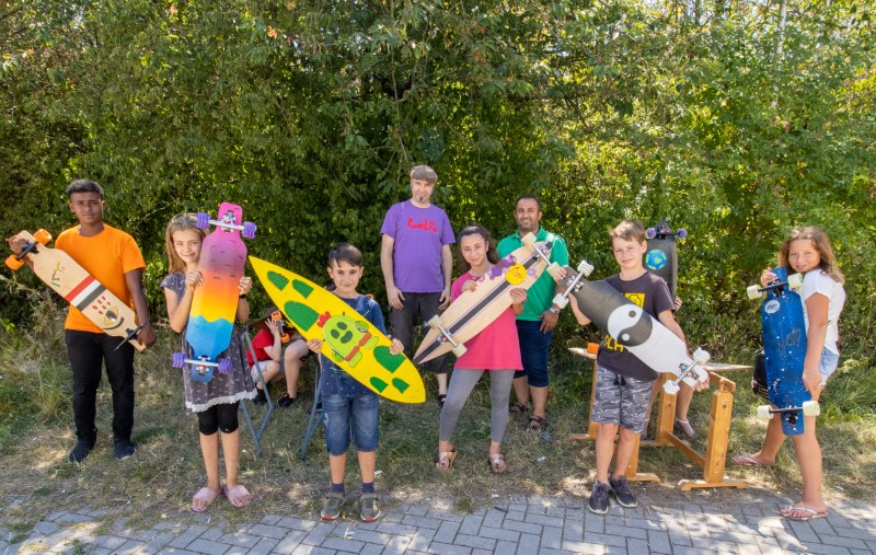 Kinder zeigen ihre selbstgebauten Longboards