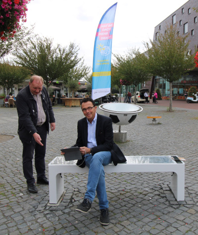 Klimaschutzmanager Rüdiger Wesseling (links) und Bürgermeister Prof. Dr. Christoph Landscheidt (rechts) beim Testen der neuen Solarbank