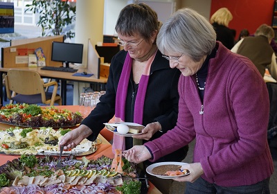 Ehrenamtliche bedienen sich am Buffet.