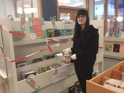 Neue Bücher für den Club sortiert Lotte Backasch, Auszubildende der Mediathek Kamp-Lintfort, in das SLC-Regal