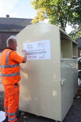 Ein Mitarbeiter beim Aufstellen der Altkleidercontainer