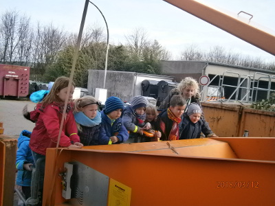 Mit großen Augen bestaunen die Kinder die Arbeit der Müllpresse
