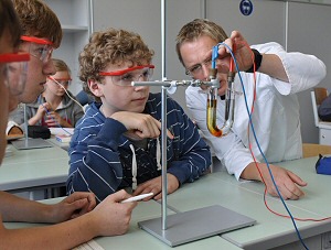 Stephan Benecken, Fachlehrer für Chemie, erklärt einer Schülergruppe seines Chemie-Kurses die Feinheiten des Versuchsaufbaus; Foto: SGKL