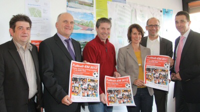 Sponsoren und Organisatoren stellen das Plakat zum Public Viewing vor.
