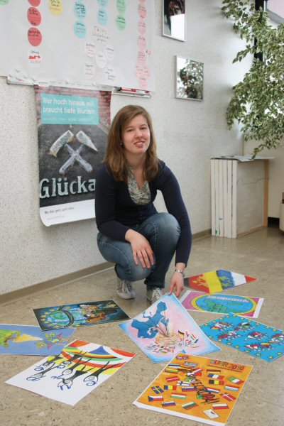 Rebecca Zomm, die im Kulturbüro das Freiwillige Soziales Jahr Kultur macht, schaut die Fahnenvorlagen durch, die Schülerinnen und Schüler aus Kamp-Lintfort und den Partnerstädten gemalt haben. 