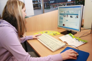 Frau recherchiert am PC in der Wir4-Onleihe